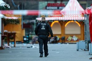 Ein Polizist geht hinter einer Absperrung am Magdeburger Weihnachtsmarkt. - Foto: Jan Woitas/dpa