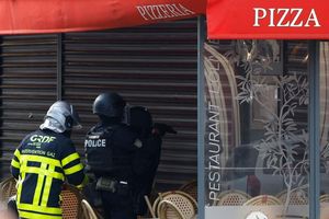 Polizisten stehen vor dem Restaurant in Issy-les-Moulineaux. - Foto: Ian Langsdon/AFP/dpa