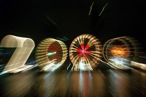 25 Jahre alt ist dieses «2000»-Foto: Ein Zoom-Effekt verfremdet eine große «2» und drei Riesenräder am Mainufer in Frankfurt in der Silvesternacht 1999/2000. - Foto: Arne Dedert/dpa