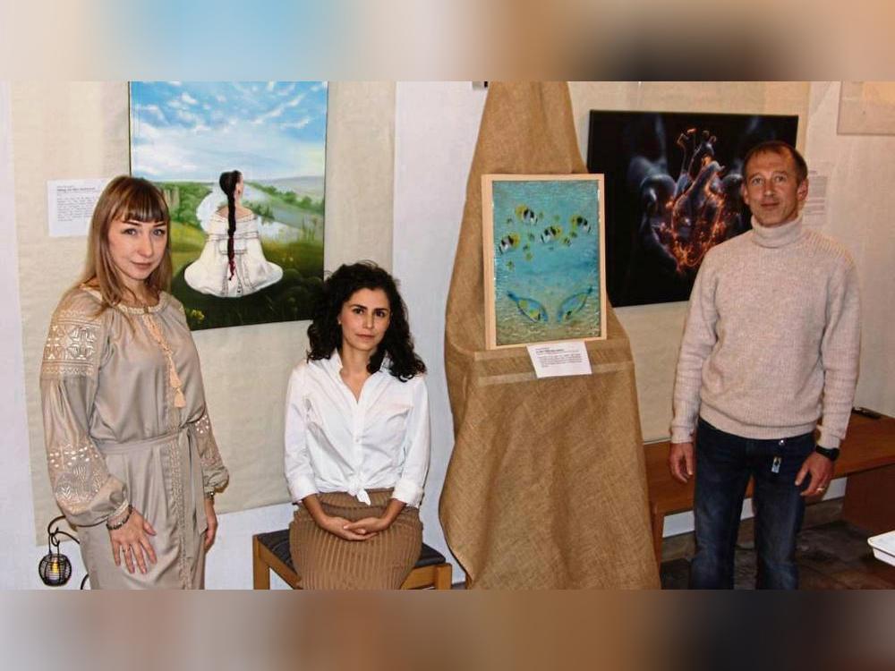 Olena Nikolaieva (l.) und Natalia Davitian (Mitte) stehen in der Ausstellung im Mittelpunkt, Vitalii Nikolaiev (r.) stellt ebenfalls ein Bild aus. Foto: Wissing