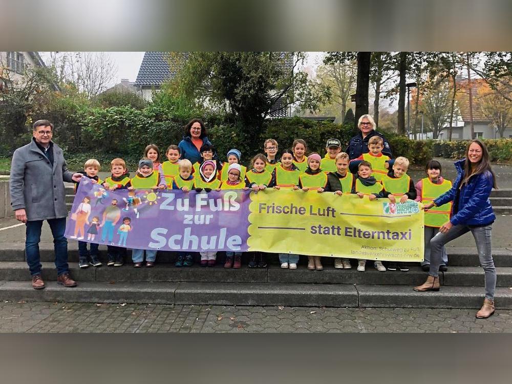 Die Klasse 2a von Petra Henke (hinten links) präsentiert das Banner für die von der Gemeinde Anröchte veranstaltete Aktion „zu Fuß zur Schule“. Foto: Mintert