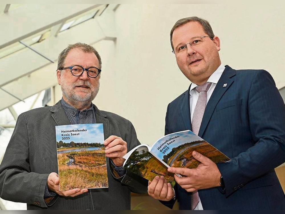 Redakteur Norbert Dodt (l.) und Dezernent Sascha Kudella präsentieren den druckfrisch erschienenen Heimatkalender Kreis Soest 2025. Foto: Hönicke (Kreis Soest)