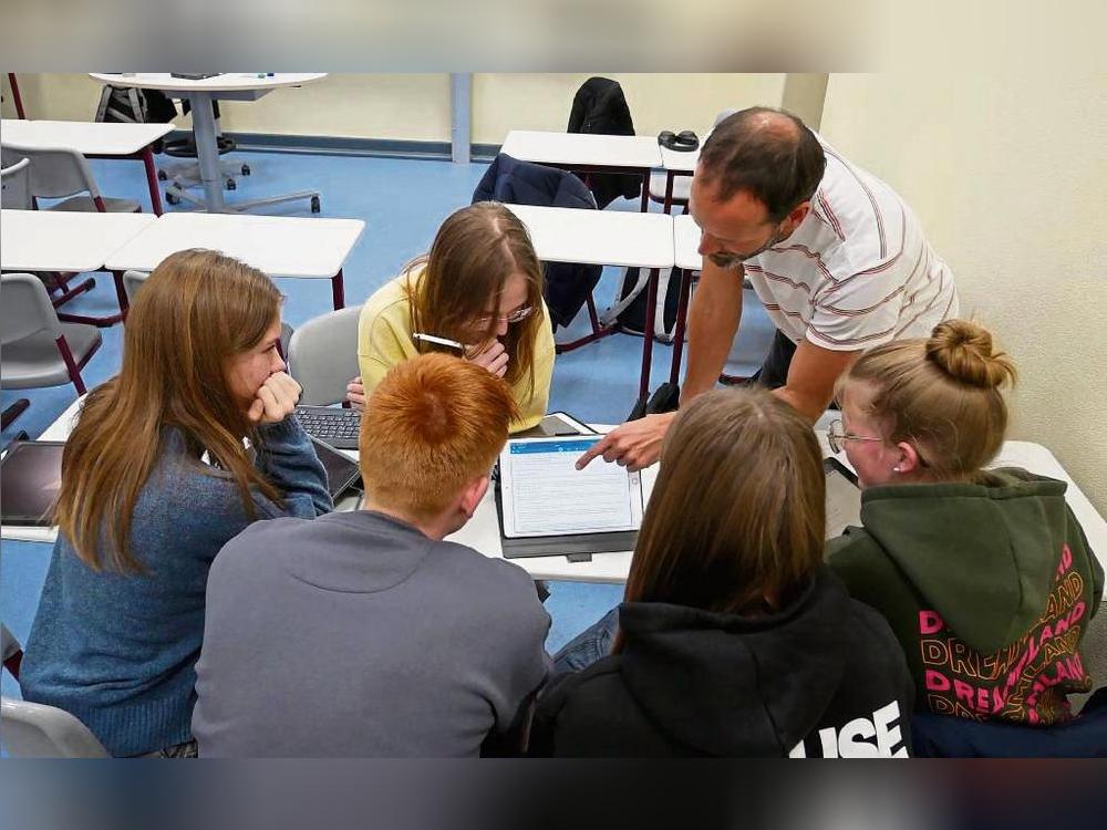 In Kleingruppen beschäftigen sich die Schülerinnen und Schüler am Friedrich-Spee-Gymnasium mit der US-Wahl. Ihr Lehrer Steffen Friedrich (r.) unterstützt sie dabei. Foto: Bsdurek