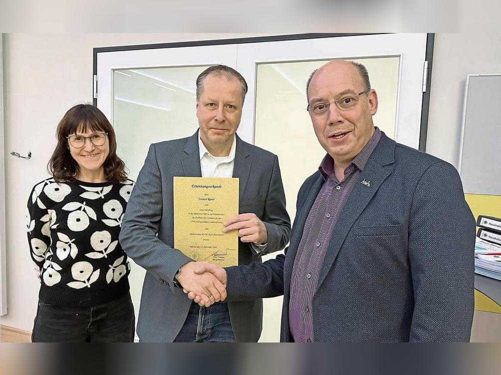 Bürgermeister Peter Weiken (r.) ernennt Torsten Reiter zum neuen Ortsvorsteher von Altenrüthen. Unterstützung bekommt Reiter von seiner Frau Sandra. Foto: Bsdurek