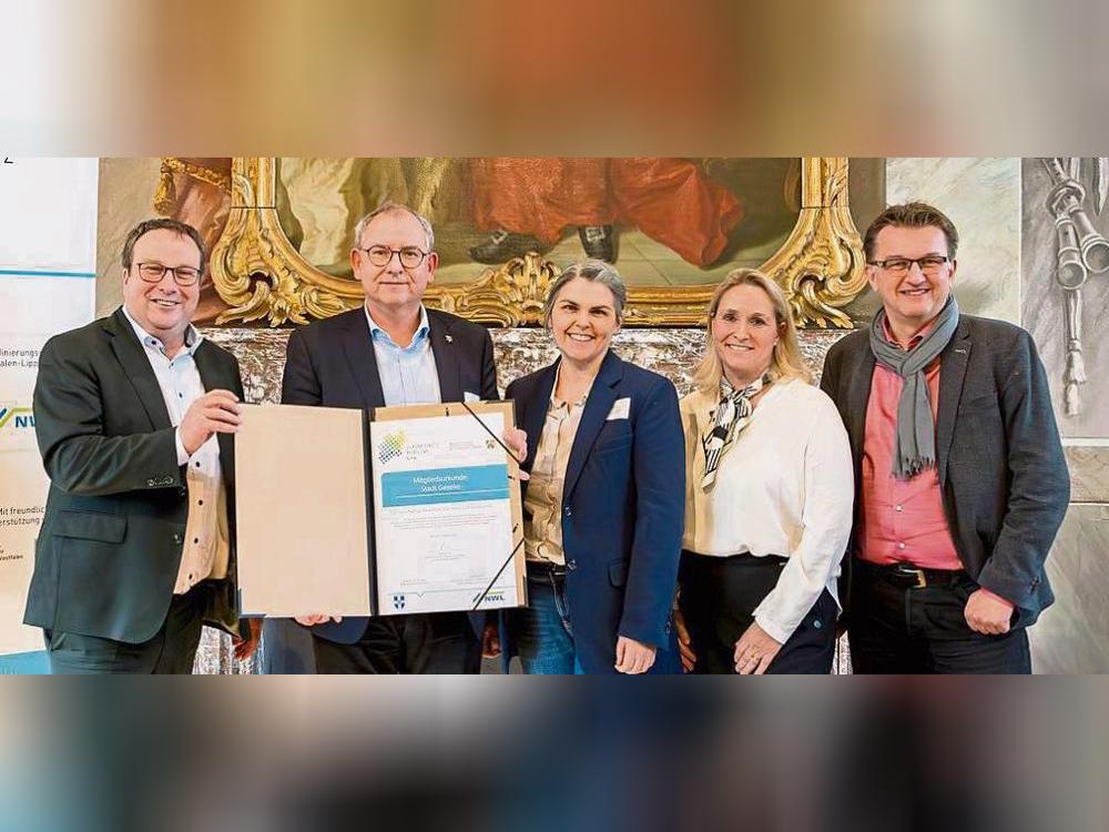 Landesverkehrsminister Oliver Krischer (v.l.) überreicht die Beitrittsurkunde zum Zukunftsnetz Mobilität an Peter Stephan (Fachbereichsleiter Stadtentwicklung) und Julia Krümmelbein (Klimaschutzbeauftragte). Daniela Niestroy (Leiterin Koordinierungsstelle Westfalen-Lippe) und Joachim Künzel (Geschäftsführer Zweckverband Nahverkehr Westfalen-Lippe) freuen sich ebenfalls. Foto: go.Rheinland GmbH/Smilla Dankert