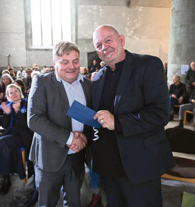 Bürgermeister Arne Moritz (l.) überreicht Kurator Dirk Raulf ein Präsent – nein, kein Geld, „etwas für den Genuss“.