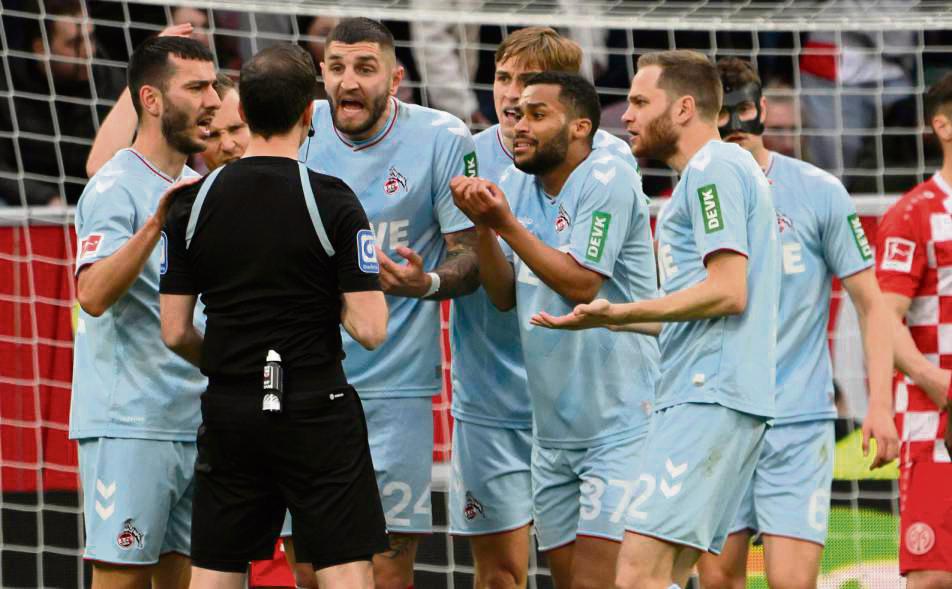 So geht’s nicht mehr weiter: Beim Bundesliga-Spiel Mainz gegen Köln vor wenigen Monaten redeten sechs FC-Spieler auf Schiri Benjamin Brand ein. Nach der neuen Regel darf nur noch der Kapitän mit dem Unparteiischen über strittige Szenen diskutieren. Foto: dpa
