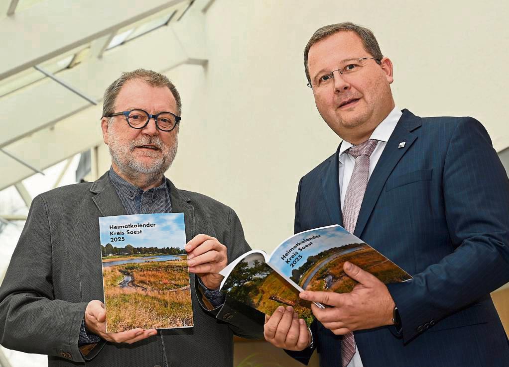 Redakteur Norbert Dodt (l.) und Dezernent Sascha Kudella präsentieren den druckfrisch erschienenen Heimatkalender Kreis Soest 2025. Foto: Hönicke (Kreis Soest)