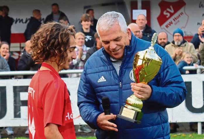 KJA-Chef Bernd Kirchhoff (r.) überreicht Ninos Lado, Spielführer der C-Junioren des SV Lippstadt, nach dem 3:0-Finalsieg gegen Warstein die Trophäe. Fotos: Feichtinger