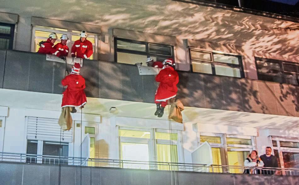Rote Hingucker: Vom Dach des Evangelischen Krankenhauses seilten sich am Mittwoch Nikoläuse ab, um den kleinen Patienten der Kinderklinik eine Freude zu bereiten.