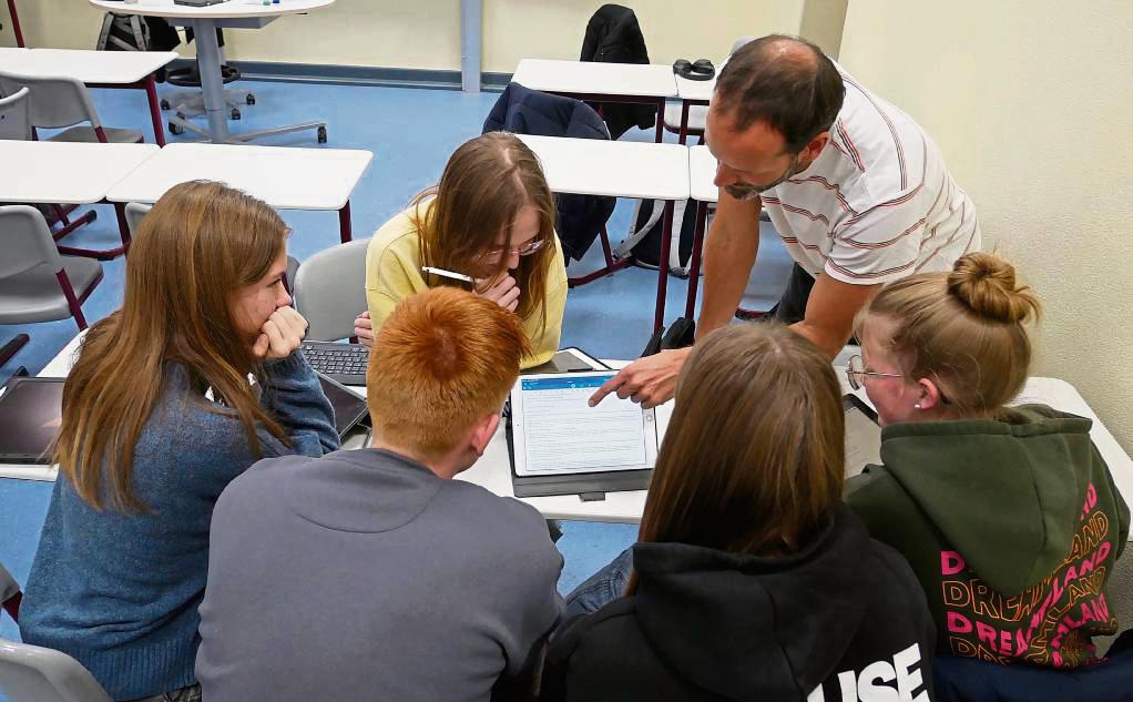 In Kleingruppen beschäftigen sich die Schülerinnen und Schüler am Friedrich-Spee-Gymnasium mit der US-Wahl. Ihr Lehrer Steffen Friedrich (r.) unterstützt sie dabei. Foto: Bsdurek