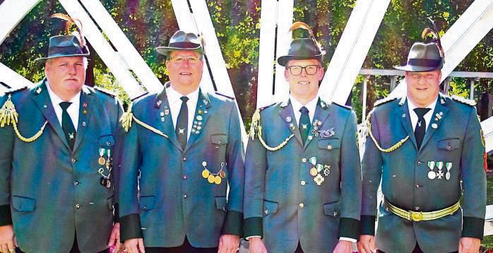 Wilfried Holtkötter (l.), Leiter der Schießriege, und Oberst Dirk Ruhnau (r.) gratulieren (v.l.) Sven Konietzko und Felix Lütke-Bornefeld. Es fehlt: Jan Holtkötter, der Sieger.