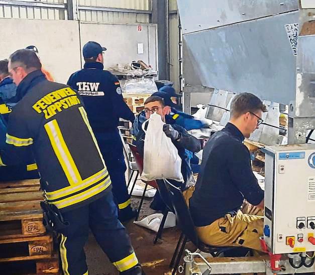 Sandsack-Tetris im Akkord: Einsatzkräfte der Feuerwehren und der Hilfsorganisationen füllten beim Baubetriebshof die weißen Beutel gegen das Wasser. Foto: Stadt Lippstadt