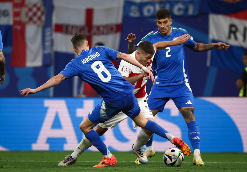 Die Italiener (blaue Trikots) sicherten sich durch ein spätes Remis gegen Kroatien das Achtelfinal-Ticket. - Foto: Jan Woitas/dpa
