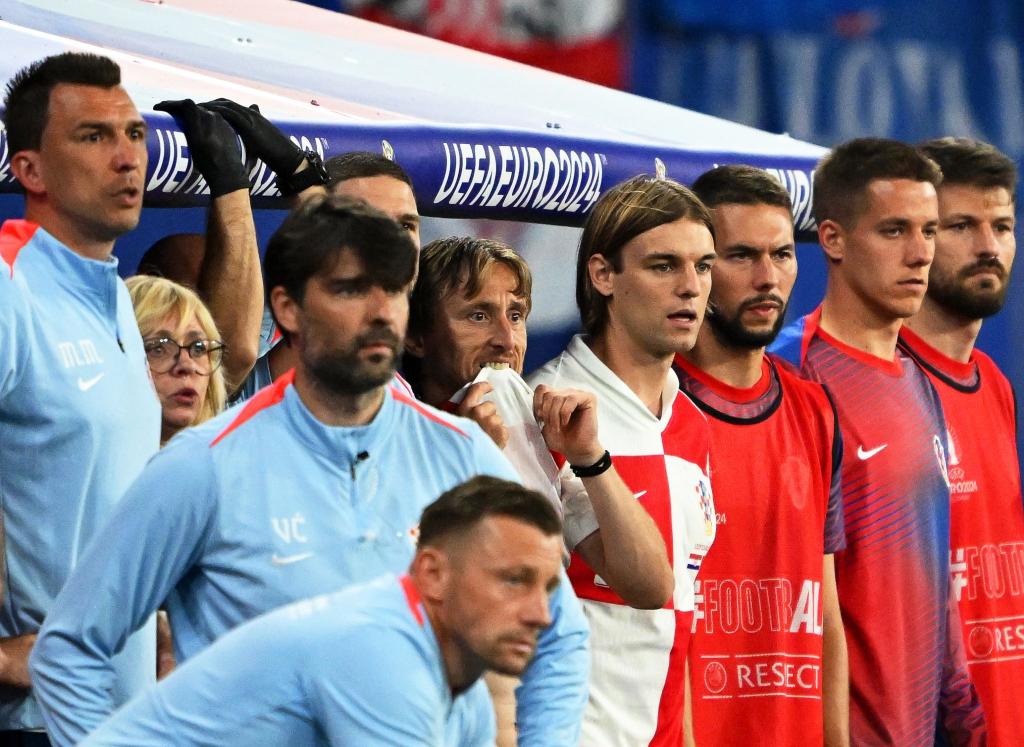 Kroatiens Luka Modric (M) und seine Teamkollegen schauen vom Spielfeldrand zu. - Foto: Robert Michael/dpa