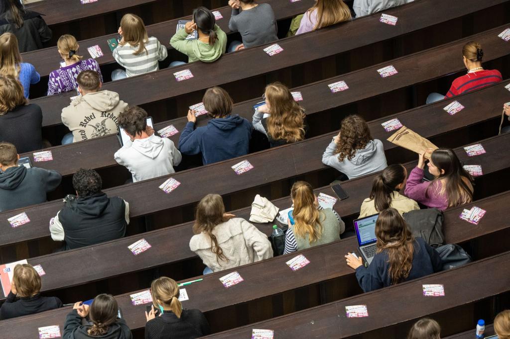 Studenten nehmen an der Einführungveranstaltung im Audimax der Ludwig-Maximilians-Universität teil. - Foto: Peter Kneffel/dpa