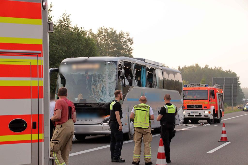 Rettungskräfte neben dem beschädigten Reisebus auf der Autobahn 24. Inzwischen ist die Sperrung aufgehoben. - Foto: SWM DV StudioRalf Drefin/dpa