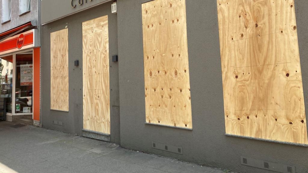 Ein Geschäft hat aus Sorge vor Ausschreitungen Bretter vor den Schaufenstern angebracht. - Foto: Marc Herwig/dpa