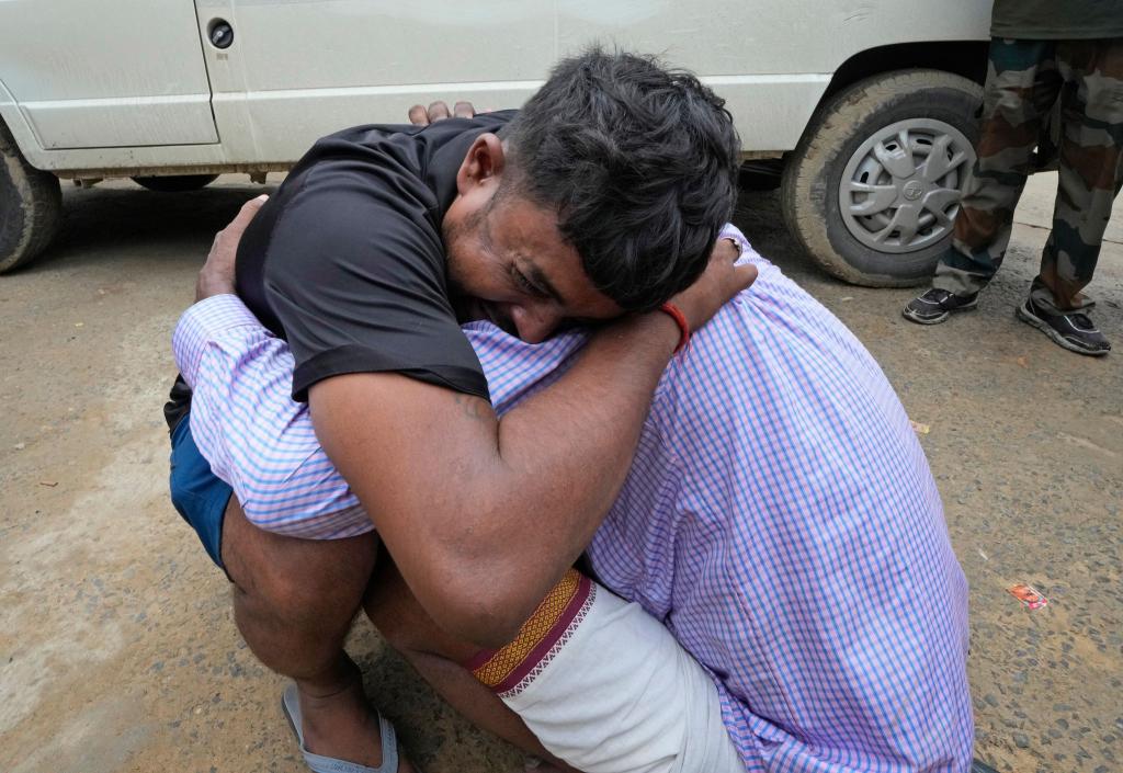Ein Mann umarmt einen Angehörigen, nachdem seine Schwester Opfer der Massenpanik wurde. - Foto: Rajesh Kumar Singh/AP/dpa