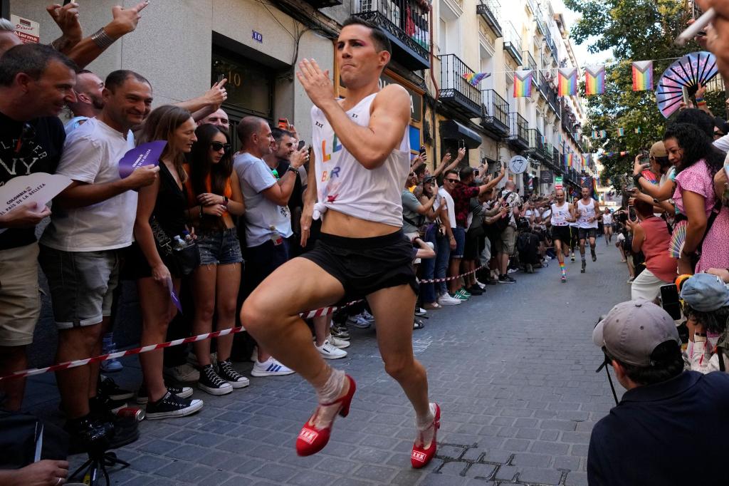 Mit großen Schritten rennt ein Teilnehmer des jährlichen High-Heels-Rennens während der Pride Week durch das Chueca-Viertel in Madrid. - Foto: Paul White/AP/dpa