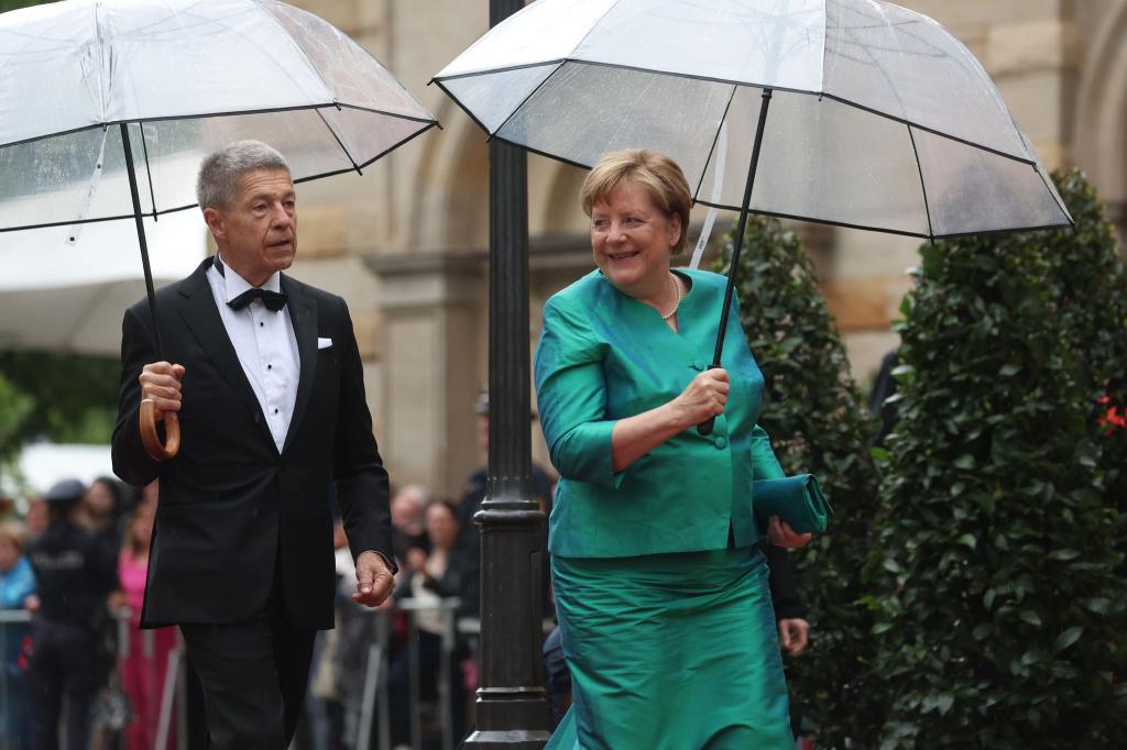 Im letzten Jahr mussten sich Angela Merkel und Ehemann Joachim Sauer auf den Weg ins Bayreuther Festspielhaus mit Regenschirmen schützen. (Archivfoto) - Foto: Karl-Josef Hildenbrand/dpa