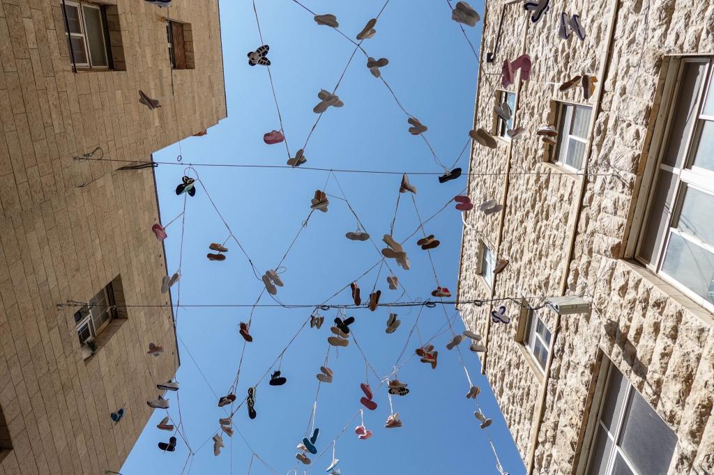 120 Paar Schuhe, als Installation in der Jerusalemer Innenstadt aufgehängt, erinnern an das Los der israelischen Geiseln in der Gewalt der Hamas. - Foto: Nir Alon/ZUMA Press Wire/dpa