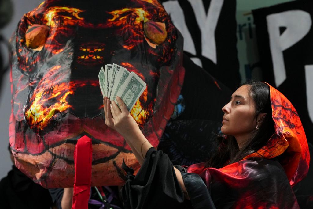 Die Schlange als Symbol der gierigen Fossilindustrie bei einer Protestaktion von Klimaaktivisten in Baku. - Foto: Peter Dejong/AP