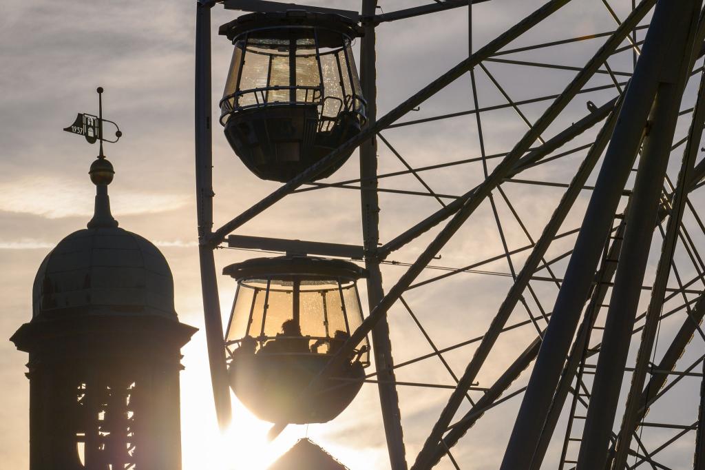 Sonnenuntergang hinter dem Riesenrad auf Weihnachtsmarkt in Magdeburg. - Foto: Klaus-Dietmar Gabbert/dpa