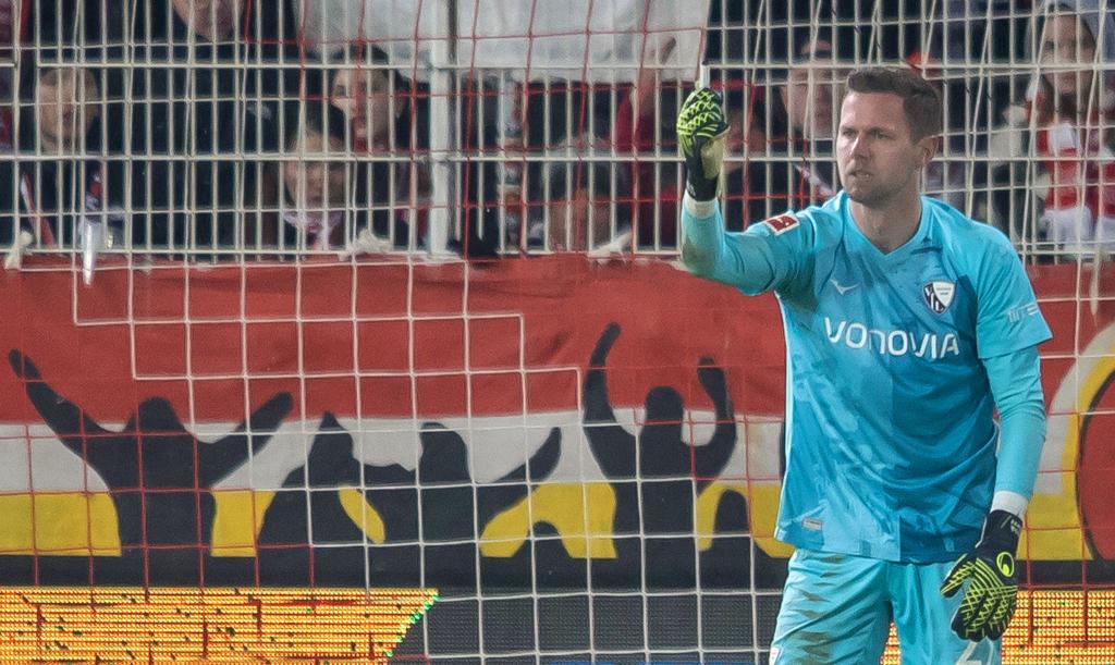 Bochums Keeper Patrick Drewes hält das Feuerzeug hoch, das ihn getroffen hat. - Foto: Andreas Gora/dpa