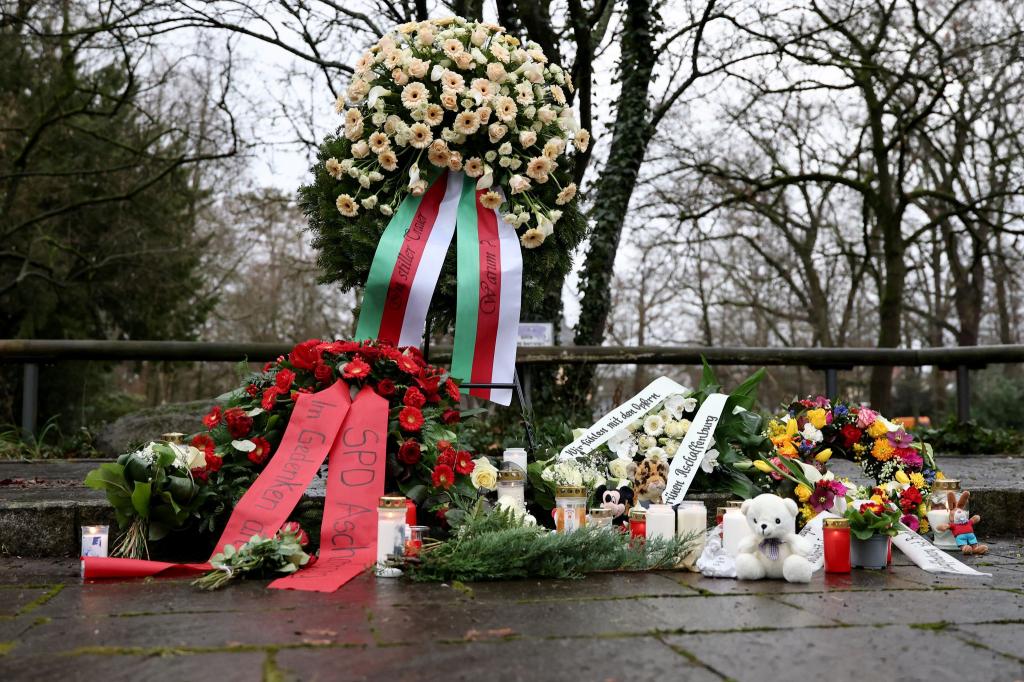 Menschen haben Blumen niedergelegt. - Foto: Daniel Löb/dpa