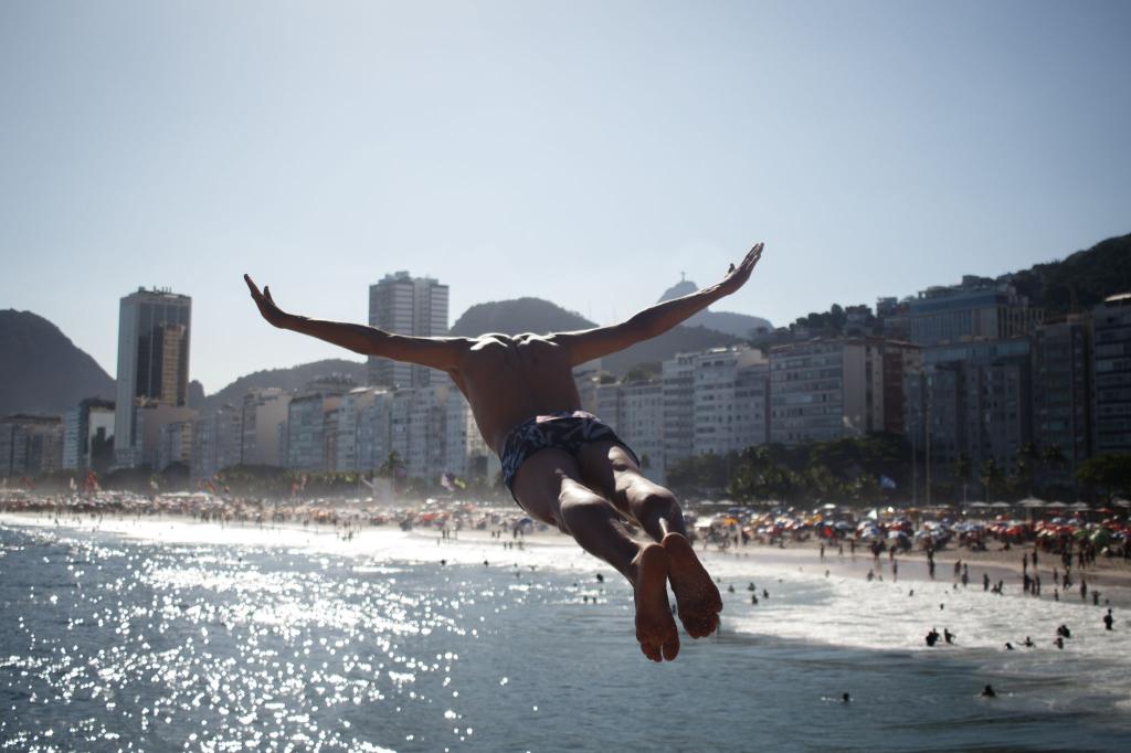 Hitzewelle in Rio de Janeiro: Ein Mann springt ins Meer am Strand Leme. - Foto: João Gabriel Alves/dpa