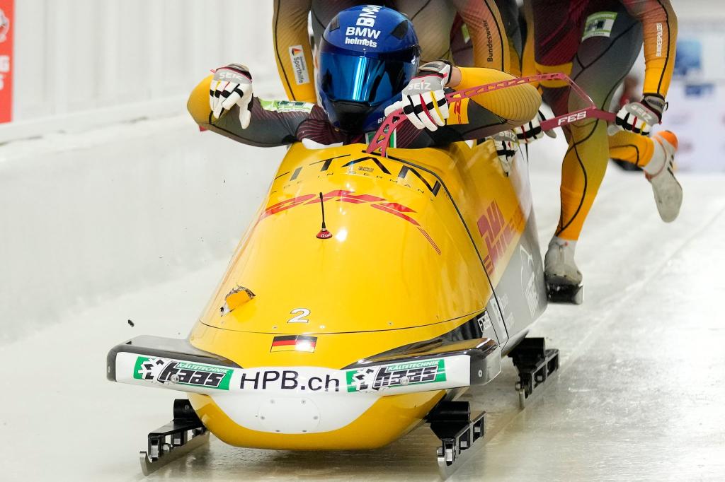 Johannes Lochner beim Start, links im Bob ist das Loch zu sehen. - Foto: Seth Wenig/AP/dpa